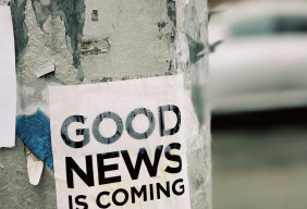 Picture of a sticker on a tree that reads "Good News Is Coming"