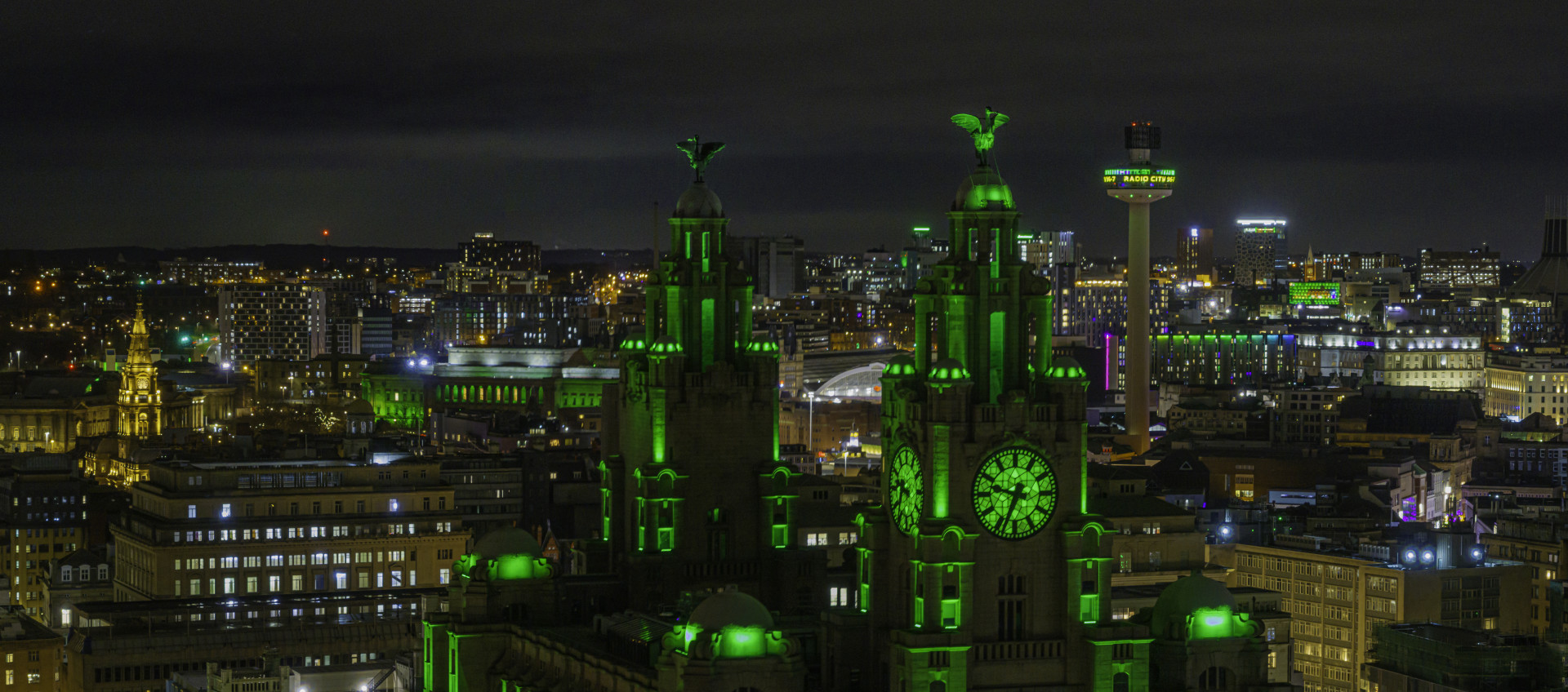 The City of Liverpool lit up in green lights at night