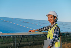 A young woman inspects solar panels. 