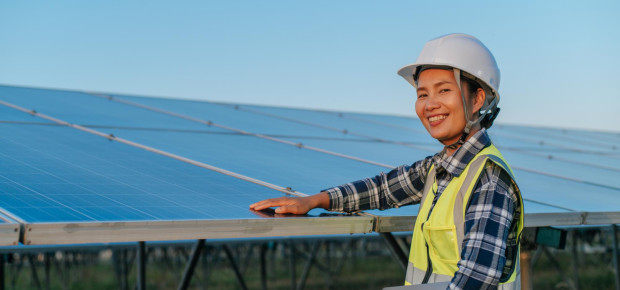 A young woman inspects solar panels. 