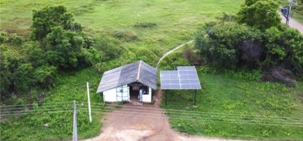 small house in rural setting with solar panels on the roof